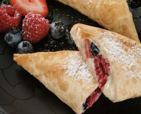 Raspberry-and-blueberry-triangles-with-creamed-cheese-dusted-with-sugar.